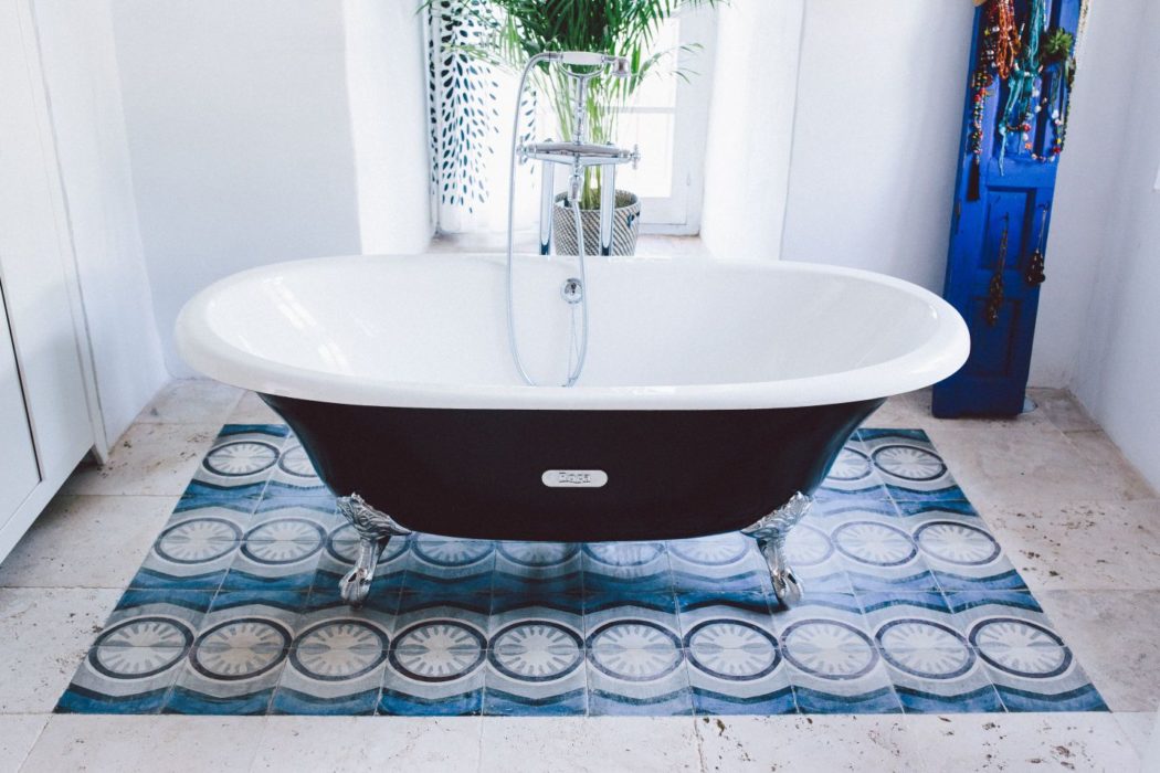 Large bathtub and ceramic blue tiles in bathroom of traditional Spain villa near Malaga