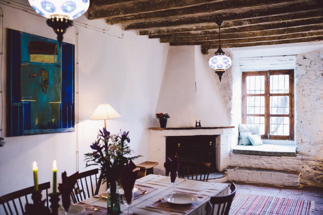 Dining room in a traditional Spanish villa with decorative lamps and a fireplace.