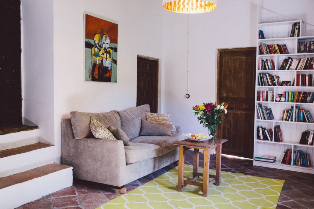 Living room in a Malaga villa with comfy sofa, ceramic tiles and bookshelves
