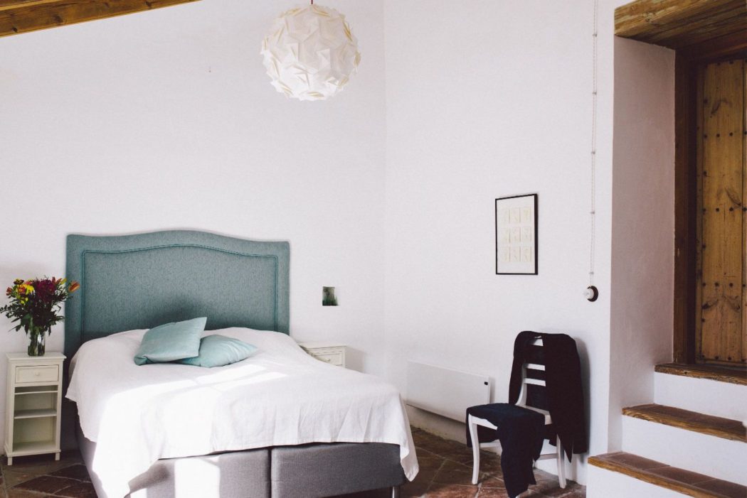 Spanish villa bedroom with a modern feel, white walls and wooden beams