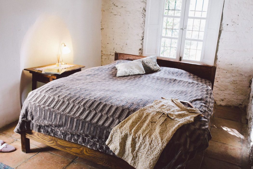 A rustic Spanish villa bedroom with a large double bed and lots of natural light