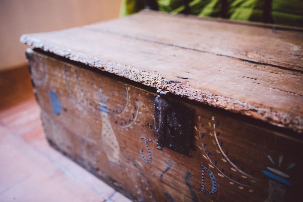 A rustic, wooden box with intricate designs on the front.
