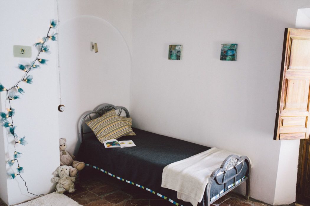 Childrens' bedroom with an open book on the bed and teddy bears